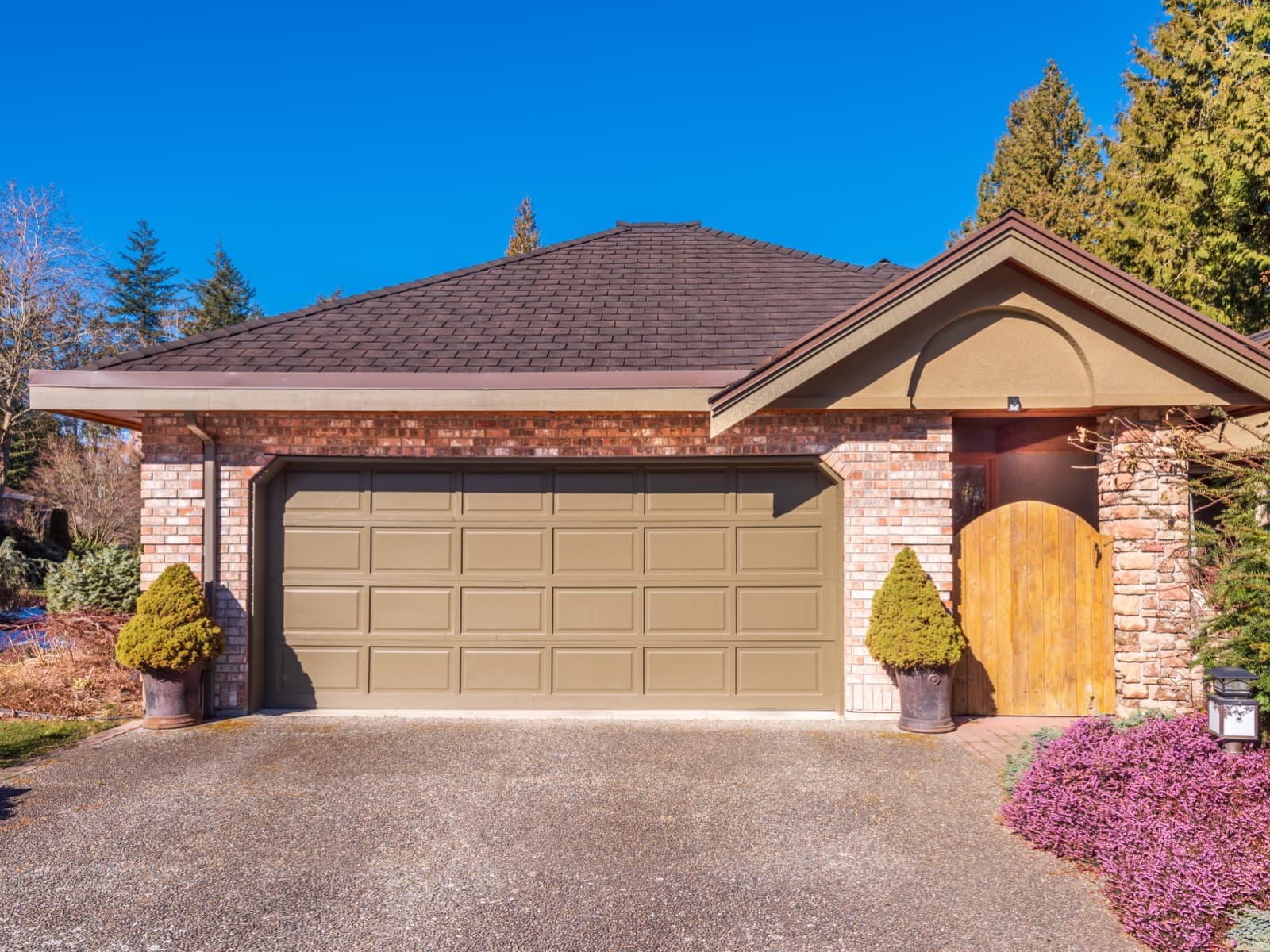 Brick house with garage in sun.
