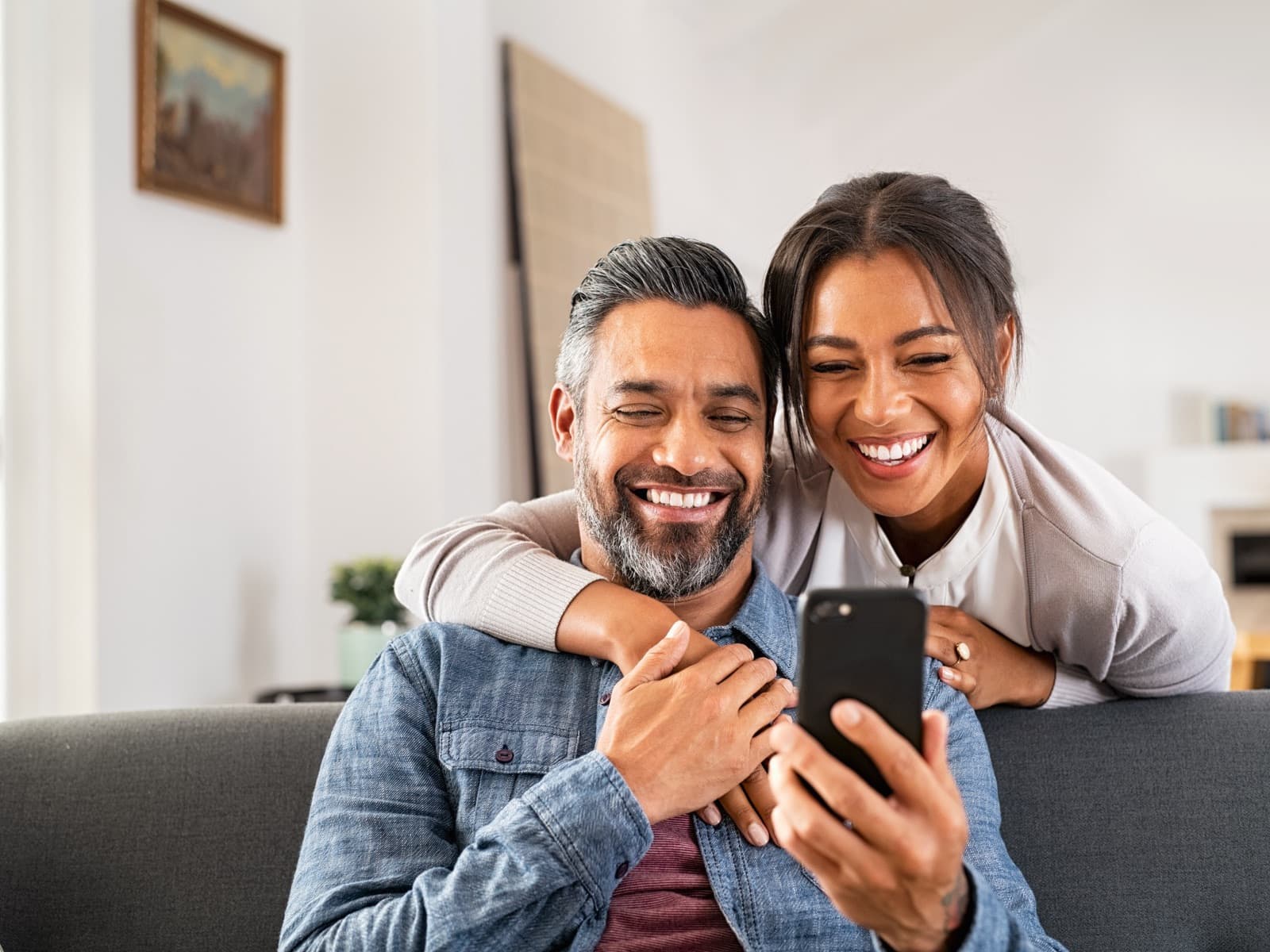 Couple taking selfie on sofa.