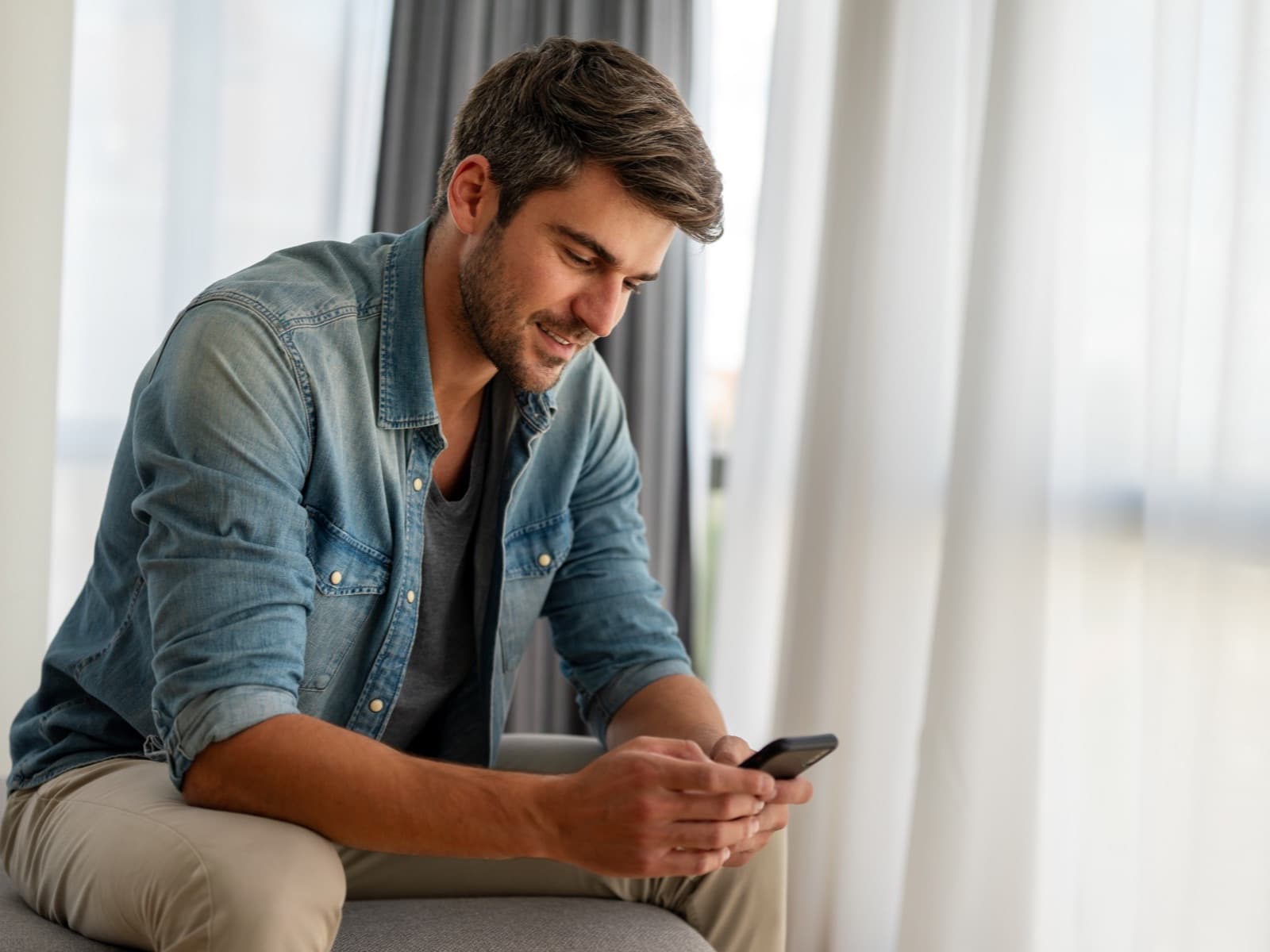 Man reading on his phone at home.