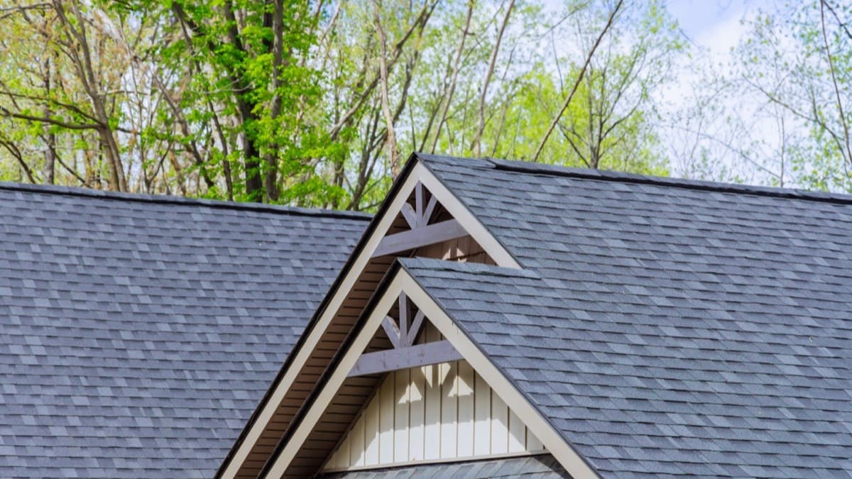 Gray asphalt shingles on a gabled house roof seen from below