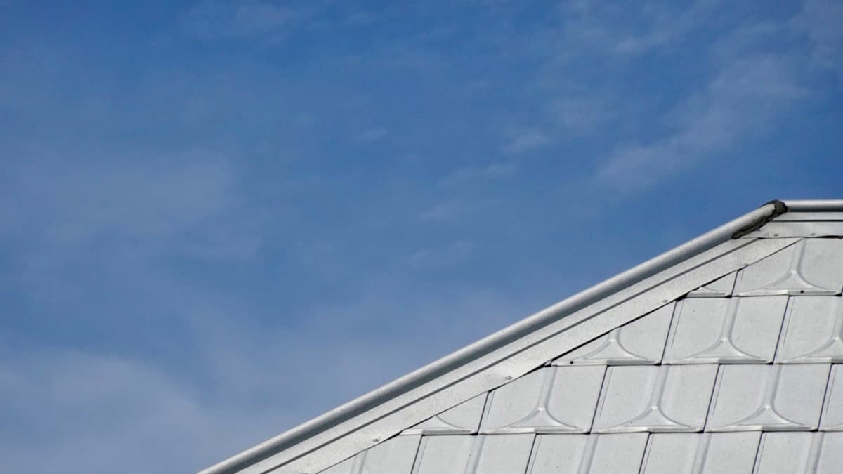 A light gray tiled roof against a bright blue sky