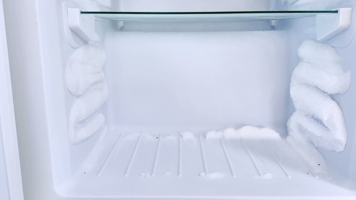 Thick frost built up on the inside walls of an empty freezer
