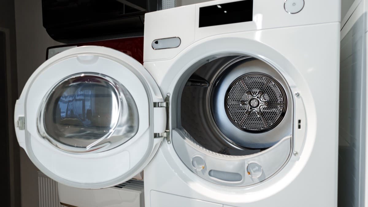 A white front-loading clothes dryer with its round door swung open, showing the perforated drum inside