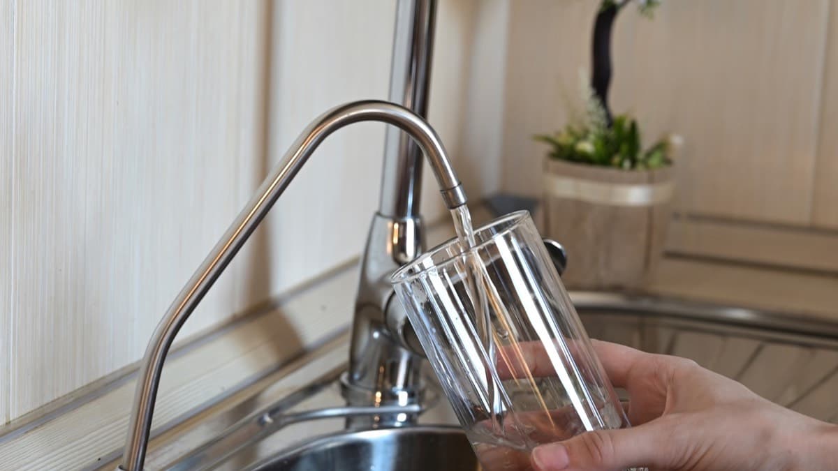 Cold water running from a kitchen faucet into a glass