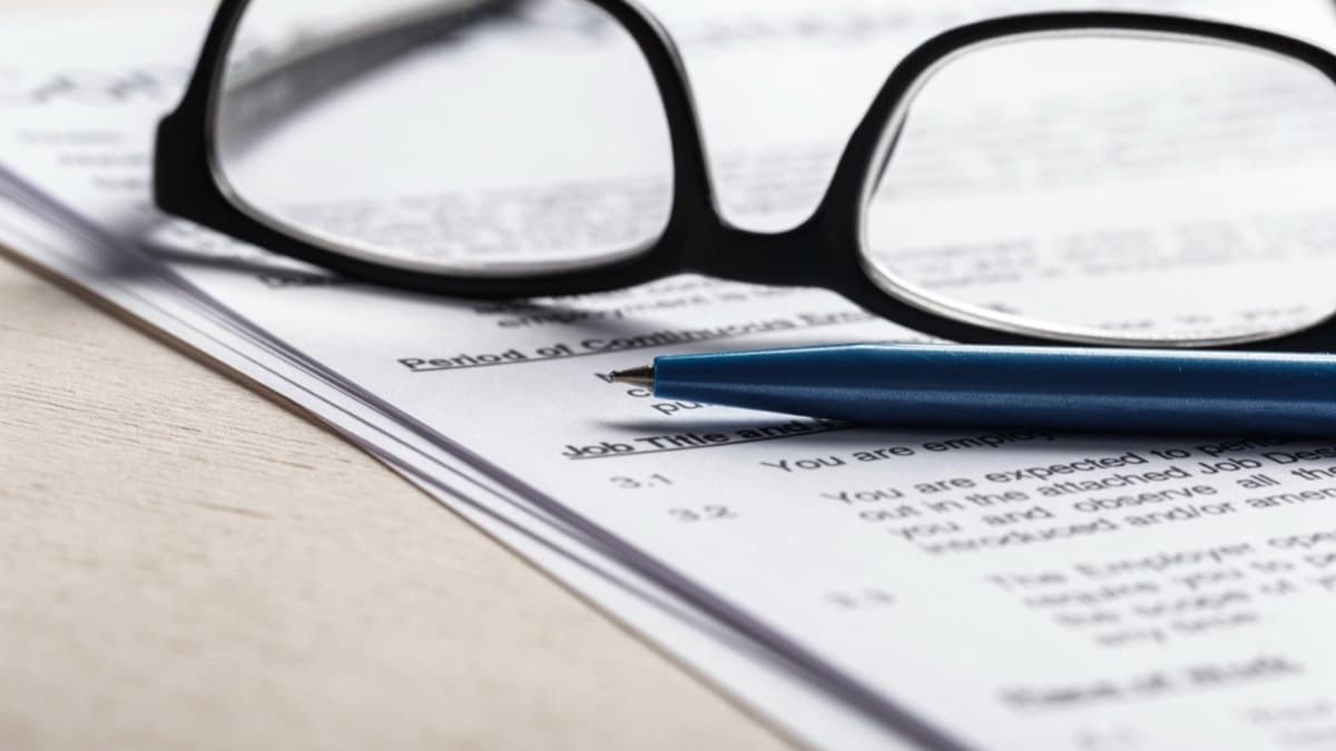 Reading glasses and a pen resting on a printed statement