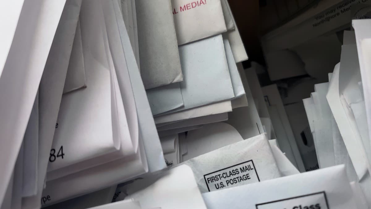 A box crammed with first-class mail envelopes