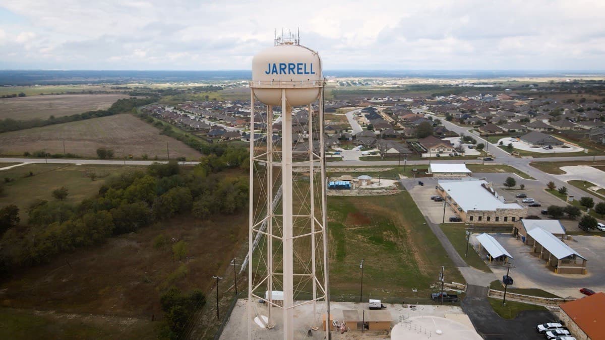 A town water tower rising above a suburban neighborhood