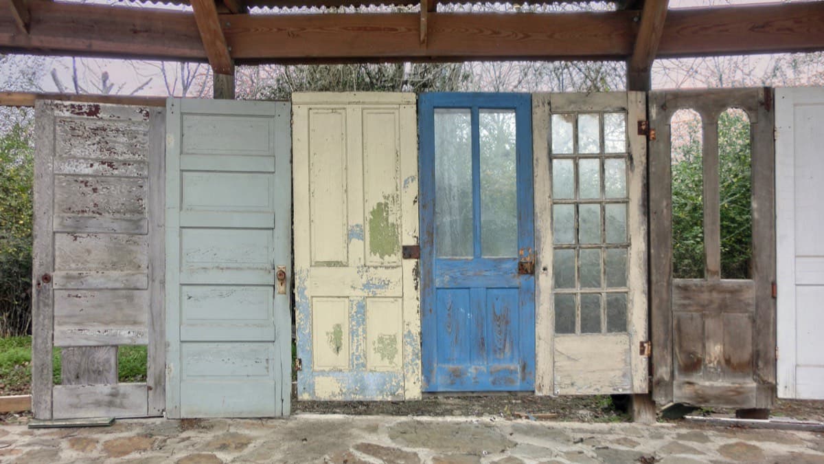 Salvaged old doors lined up under a wooden shed roof