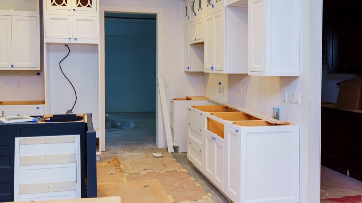 A half-finished kitchen remodel with new white cabinets installed and the countertops not yet on