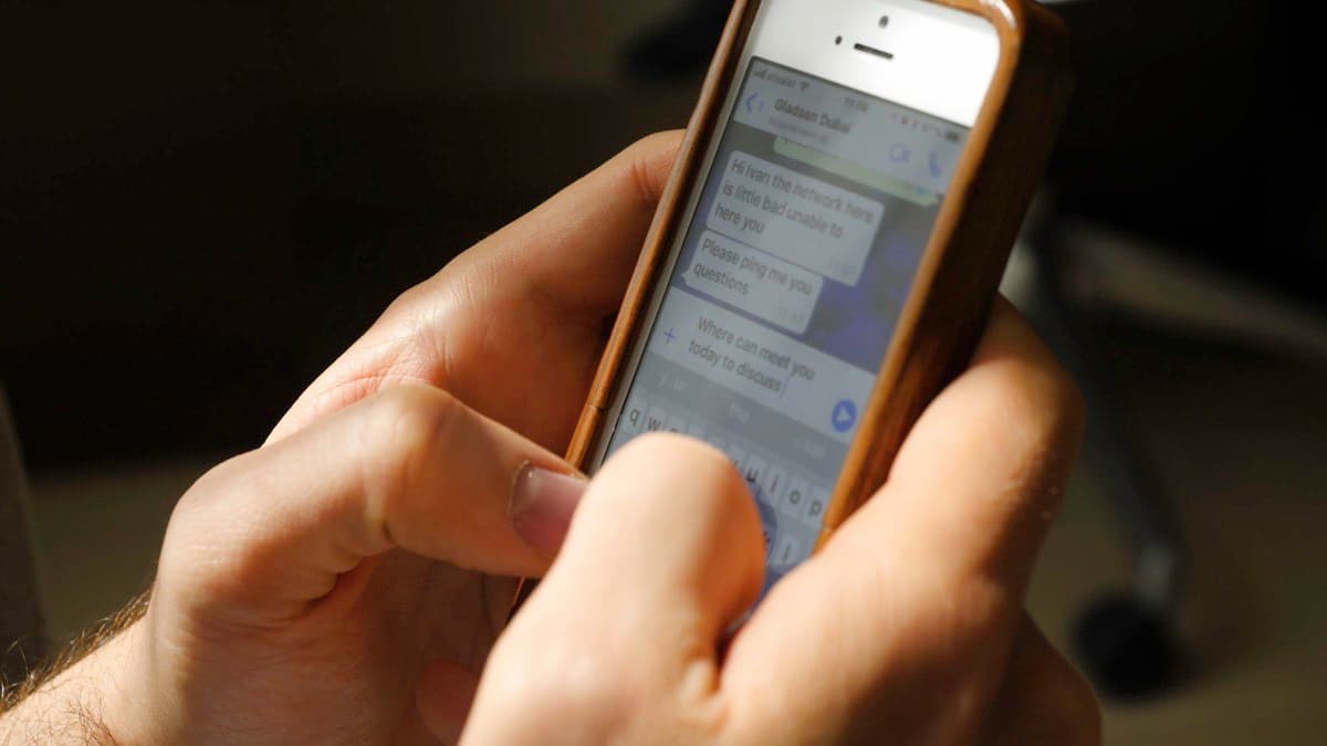 Hands holding a smartphone open to a text message thread