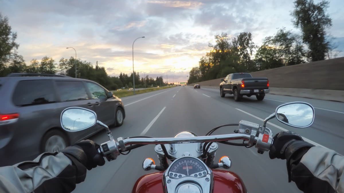 A motorcyclist's view of a highway with a minivan and a pickup in the next lanes
